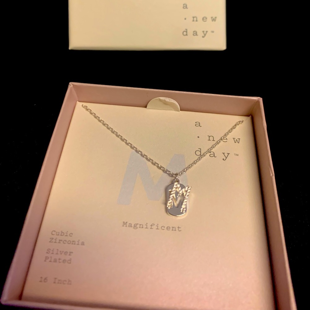 Silver finished /cubic zirconia “M” necklace.  26 inches.  Brand new in box